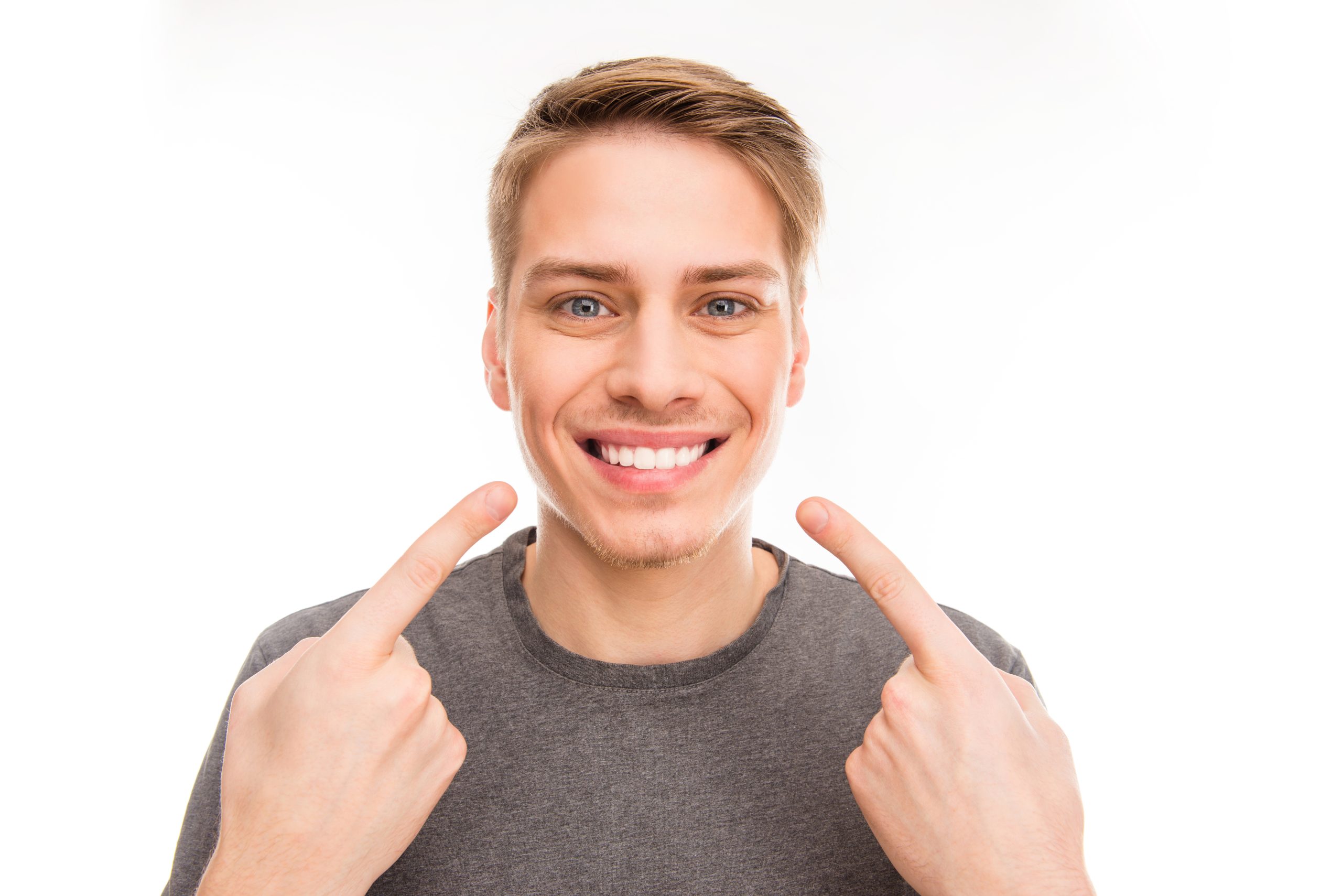 Smilling handsome man gesturing and pointing on his teeth